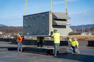 RBI employees installing an HVAC unit on top of a building
