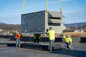 RBI employees installing an HVAC unit on top of a building