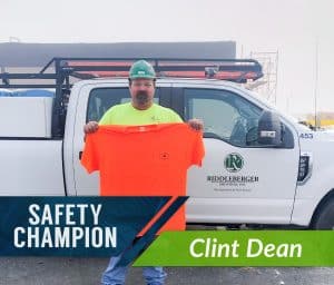 Clint Dean, RBI's October Safety Champion, holding an RBI t-shirt in front of an RBI truck.