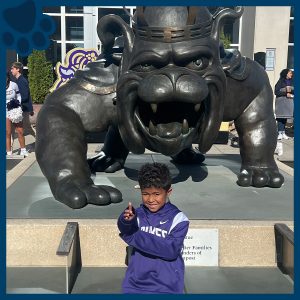 RBI's Top Dog Winner in front of a statue of JMU's Duke Dog