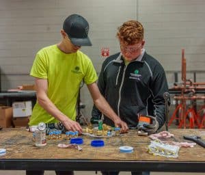 RBI refrigeration mechanic, Caleb Jerrels, working with a coworker looking at pipes.