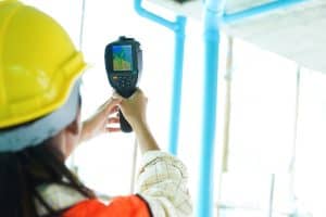 A technician using a heat tool to conduct an energy test.