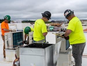 RBI technicians installing a rooftop HVAC unit.