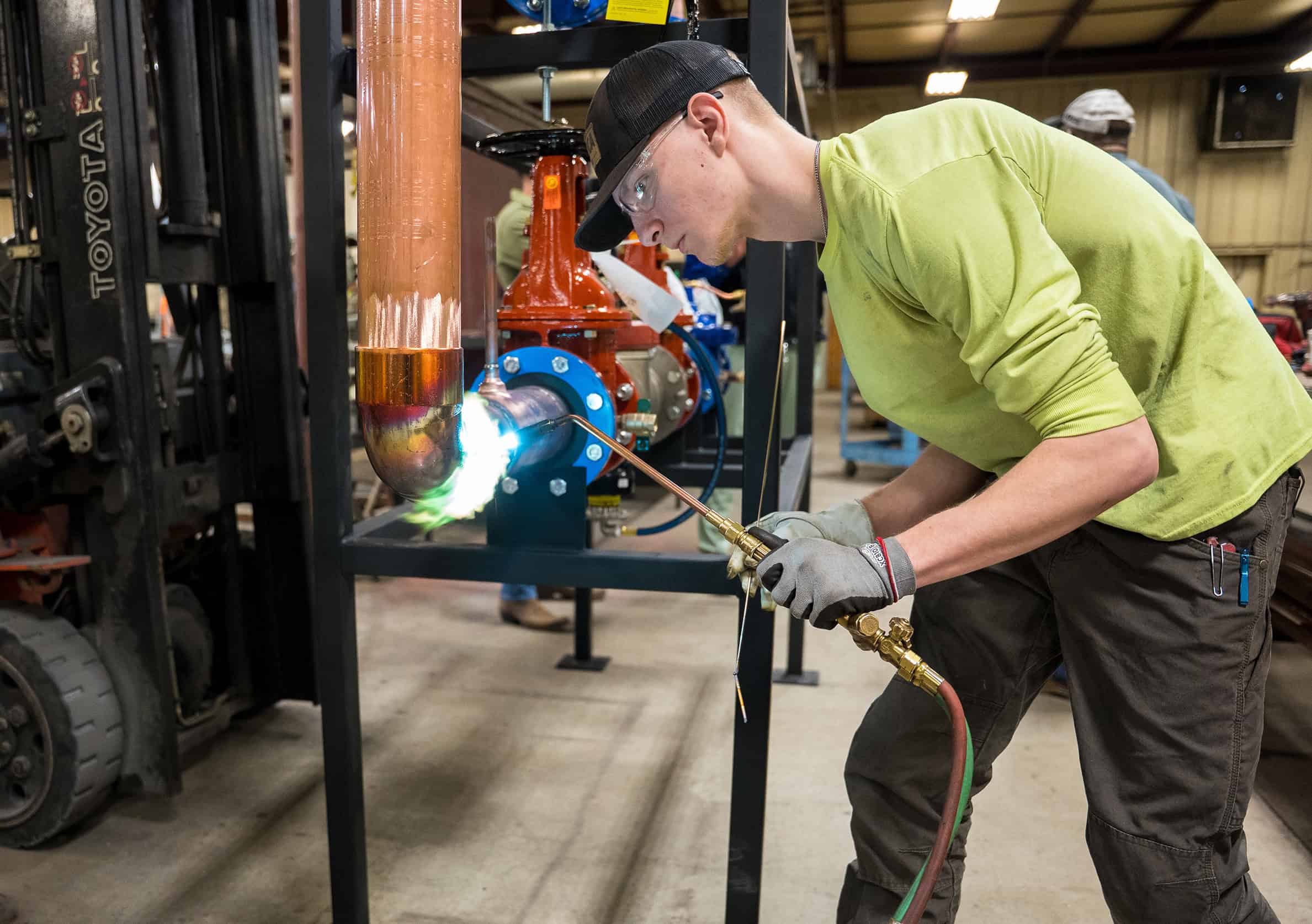 An RBI employee welding a pipe together in RBI's prefab shop